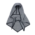 Close-up of black and white houndstooth knit hooded poncho with premium stitched edges - Black