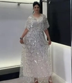 Dettaglio dei ricami di paillettes bianche e del design mantella elegante sull'abito da sera - Taglia unica / Albicocca