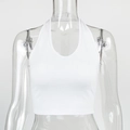 Detail of white ribbed knit halter neck crop top showing V-neckline and fabric texture - White