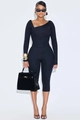 Detail view of black asymmetric neck jumpsuit with slim fit long sleeves and cropped pants - S / Black