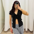 Detail van de zwarte crop top met V-hals, strik aan de voorkant en korte mouwen - S / Zwart