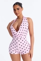 Dettaglio di pagliaccetto rosa a pois neri con allacciatura al collo e scollo a V - S