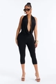 Detail of deep V-neckline with gold studs on a black sleeveless halter jumpsuit - S / Black