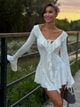 Detailed view of the deep V-neckline with ruffles and tie string on the white dress - White
