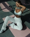 Detailed view of a white sports bra and flared yoga pants set in a gym workout scene - S / White Pants