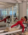Rotes Yoga-Set mit Neckholder-Sport-BH und Leggings auf Pilates-Geräten in Aktion - S / Leuchtend Rotes Langes Set
