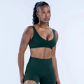 Close-up of seamless dark green sports bra and high-waisted shorts on a model - XS / Pine Green