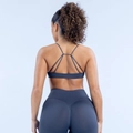 Detail der überkreuzten Träger am anthrazitfarbenen nahtlosen Sport-BH und der Yoga-Leggings - Blaugrau