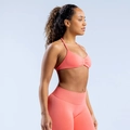 Detailansicht des korallenrosa Halter-Sport-BHs und der Leggings mit geraffter Textur - XS / Korallenrot