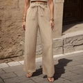 Dettaglio dei pantaloni a gamba larga plissettati beige con vita paperbag e cintura a fiocco - S / Albicocca