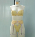 Detailed macro of yellow lace bra set featuring purple bows and scalloped floral textures - S / Ginger Yellow