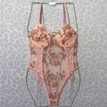 Close-up of pink butterfly embroidery and lace details on a sheer mesh bodysuit - S / Pink