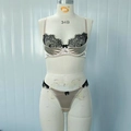Completo intimo in raso champagne con pizzo nero e fiocchi esposti su un manichino - S / Albicocca