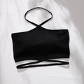Detalle de top tipo halter negro sin costuras con correas cruzadas sobre fondo blanco - S / Negro