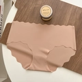 Nude seamless ice silk panties featuring laser-cut wavy edges on a wooden display - Deep Skin