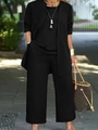 Dettaglio di un set tre pezzi nero composto da cardigan lungo, top e pantaloni larghi - Taglia S / Top E Pantaloni / Nero