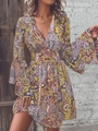 Detail of bohemian yellow paisley dress showing deep V-neckline and bell sleeve design - S / Yellow