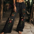 Detail van een zwarte bohemien broek met wijde pijpen, bloemenborduursels en trekkoord - Zwart