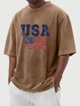 Close-up of distressed USA flag print and vintage washed fabric on brown t-shirt - Brown