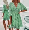 Detailed view of green floral dress featuring a V-neckline and smocked waist design - Green