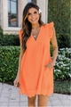 Detail of bright orange V-neck eyelet dress with ruffled shoulders and scalloped hemline - Orange