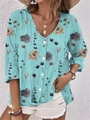Detailed close-up of light blue floral V-neck chiffon blouse with elegant white buttons - Cyan