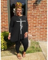Dettaglio del top a maniche lunghe taglie forti con stampa faith e pantaloni neri - L / Nero