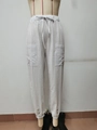 Dettaglio dei pantaloni in lino bianco con coulisse elastica e tasche a toppa laterali - S / Bianco