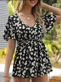 Black V-neck floral summer top with daisy prints and ruffle sleeves outdoors - S / Black