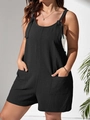 Detail showing the black jumpsuit textured fabric with front pockets and knotted straps - Black