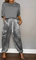 Dettaglio del tessuto in raso grigio liscio e delle tasche cargo del completo a due pezzi - Taglia S / Top E Pantaloni / Grigio