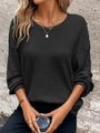 Close-up of black waffle knit texture on a loose crewneck sweatshirt with ribbed cuffs - Black