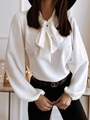 Close-up of white long sleeve blouse featuring a large elegant bow tie at the neckline - S / White