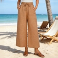 Dettaglio dei pantaloni a gamba larga con coulisse elastica e ampie tasche frontali - S / Arancione