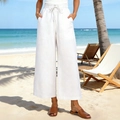 Dettaglio di pantaloni in lino bianco a vita alta con coulisse e tasche in spiaggia - S / Bianco