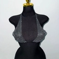 Dettaglio del top all'americana argento con cristalli scintillanti su manichino nero da studio - S / Nero