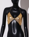 Dettaglio di un top halter in maglia metallica dorata di lusso con coppe a triangolo lucide - Oro