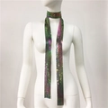 Dettaglio della sciarpa con paillettes metalliche sfumate viola e verde su manichino - Bianco AB