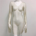 Détail d'une robe en maille dorée à manches longues avec strass brillants et décolleté en V - Col en V / Or