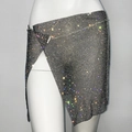 Close-up of asymmetric rhinestone party skirt with metallic mesh and side slit detail - Black