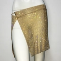 Macro detail of asymmetric gold rhinestone mesh skirt with high slit for party wear - Gold