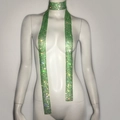 Detailed view of long green rhinestone scarf necklace on white display mannequin - Green