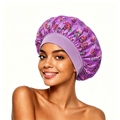 Detailed view of purple floral satin sleep bonnet with a wide elastic headband on model - Deep purple