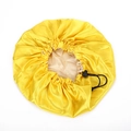 Detail of yellow satin sleep cap showing the adjustable black elastic drawstring and buckle - One Size / Yellow