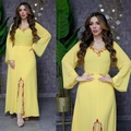 Détail d'une robe en mousseline jaune citron avec broderie de paillettes rouge et or - Jaune