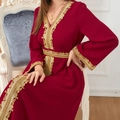 Dettaglio dell'elegante abito lungo rosso scuro con ricami dorati in vita e sulle maniche - M / Rosso