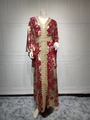 Detail of red kaftan dress featuring gold foil print and intricate geometric embroidery - Red