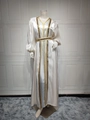 Detail of golden sequined embroidery and shiny satin fabric on a white kaftan set - Apricot