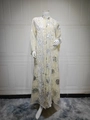 Close-up of beige kaftan dress featuring white floral embroidery and silver sunflower patterns - S / Apricot