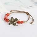 Ethno-Webarmband mit tiefroten Keramikperlen und einem Vintage-Bronze-Schmetterlingsanhänger - Blumenglasur Rot
